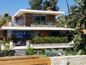 Callender's House Of Glass modern building with glass windows and sliding doors surrounded by tropical landscaping