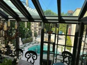 Callender's House Of Glass outdoor pool patio with glass roof and windows