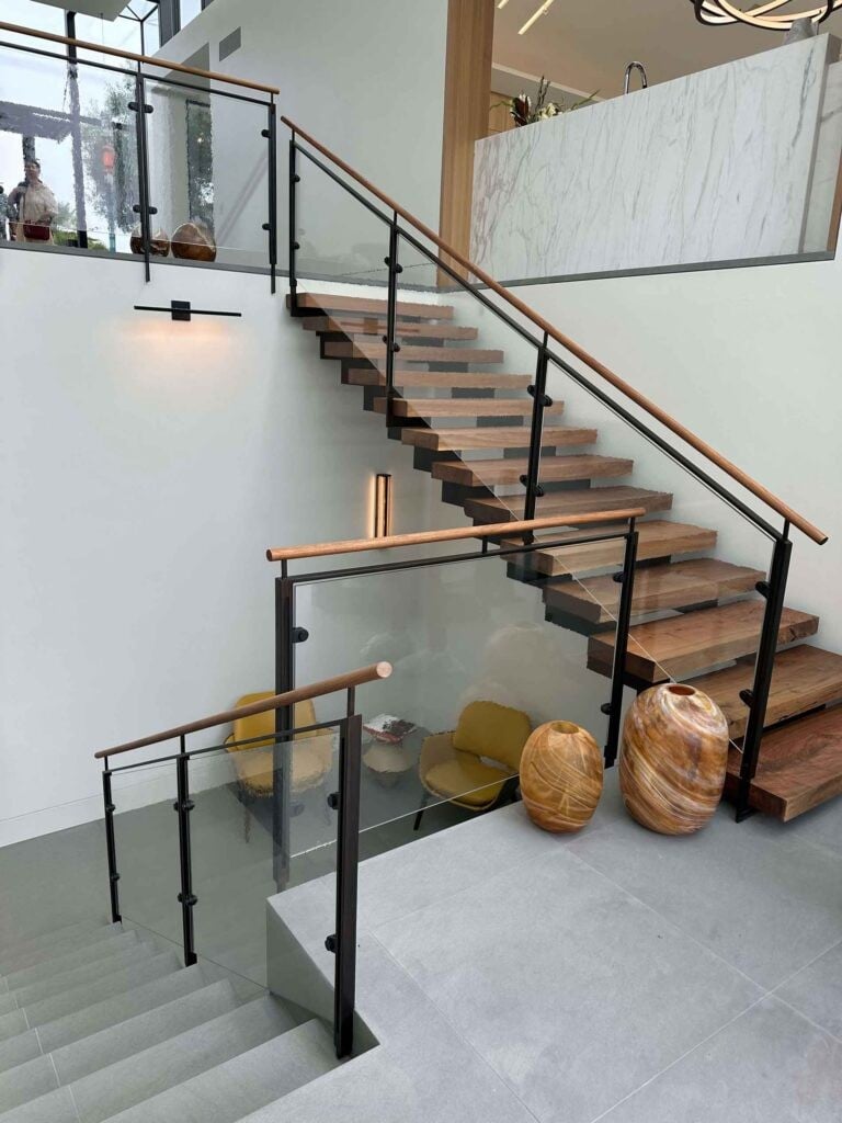 Modern glass stair railing and wooden handrails inside a Callender's House Of Glass showroom