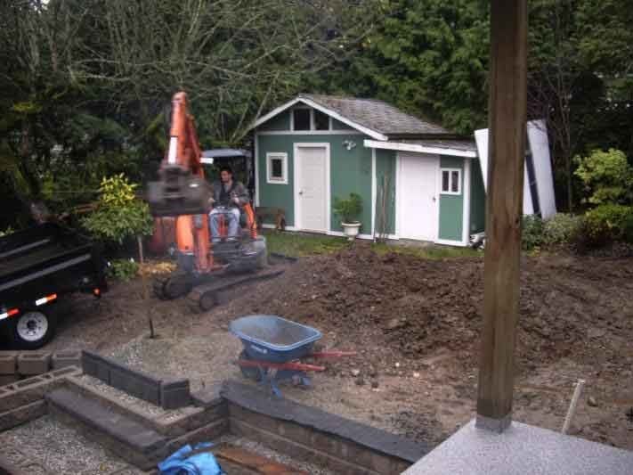 Oasis West Land Design landscaping crew building a backyard with a shed and wheelbarrow during outdoor construction
