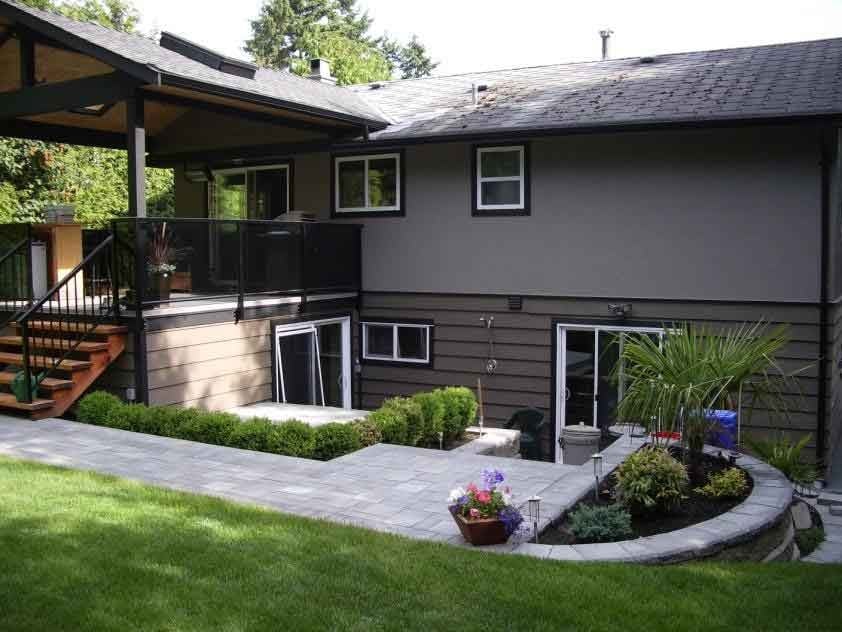 Oasis West Land Design landscaped backyard with patio, plants, and pathways beside a modern home