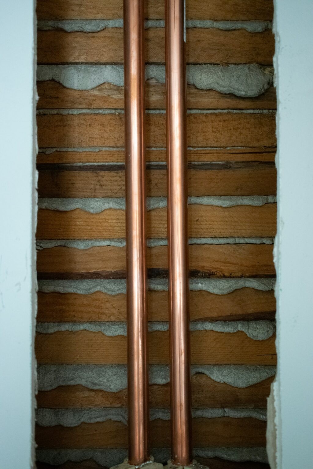Copper plumbing pipes installed in a brick wall cavity by R J Carroll & Sons Plumbing