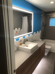 Modern bathroom with double vanity sink and tiled shower wall