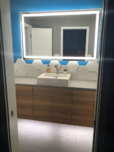 Protractor Roofing bathroom vanity with mirror and modern hex tile backsplash