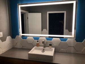Modern bathroom vanity with hex tile backsplash by Protractor Roofing