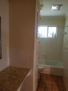 Protractor Roofing bathroom with shower and tiled walls