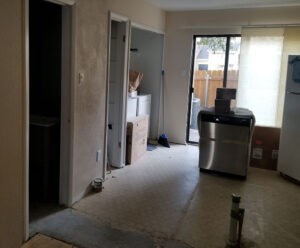 Indoor view of a home interior during remodeling with open doorway and patio door, by Protractor Roofing