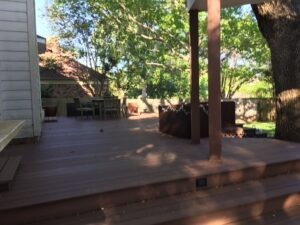 Backyard patio with trees and fencing at a Protractor Roofing service property