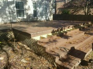 Protractor Roofing crew repairing a damaged residential roof with metal decking and fallen leaves in a backyard