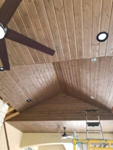 Protractor Roofing inspection of a wooden ceiling soffit under construction with recessed lights and fan
