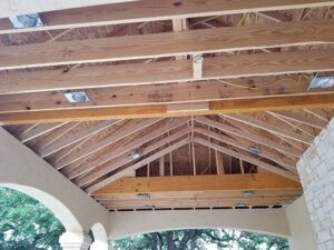Exposed wooden roof trusses during construction at a Protractor Roofing project
