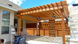 Protractor Roofing showing a new wood pergola roof frame over an outdoor patio with ceiling fans