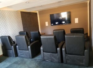 Protractor Roofing business office meeting room with projection TV and leather recliner seating
