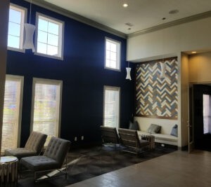 Protractor Roofing interior photo of a modern waiting area with dark blue walls and decorative wall panels
