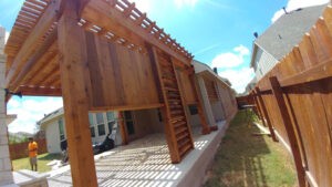 Protractor Roofing team installing a new wooden roof frame over a residential patio walkway
