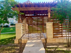 Protractor Roofing photo of a wooden pergola structure with landscaped yard and walkway