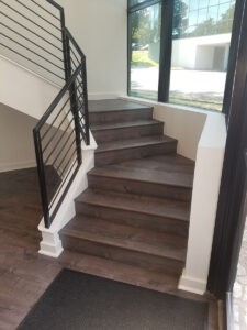Modern entryway stairs and railing with large windows from Protractor Roofing