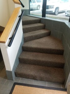 Indoor staircase with carpeted steps and handrail
