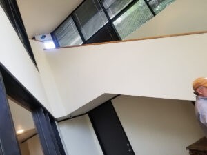 Protractor Roofing worker installing roof flashing in a commercial interior skylight area