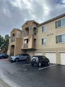 Protractor Roofing residential building roof and exterior with vehicles in parking lot