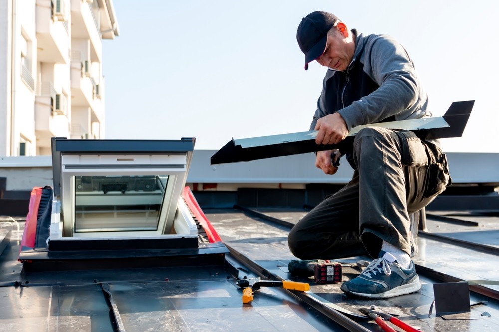 Vazquez Roofing Inc. technician installing roofing materials on a building roof