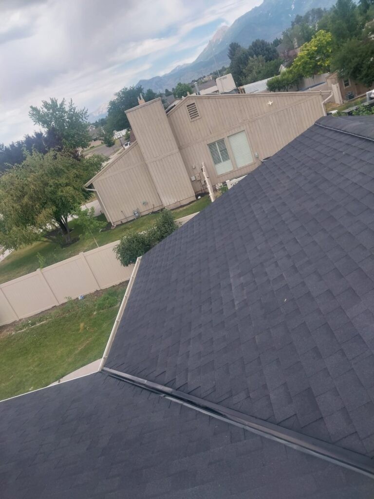 A+ Roofing Services rooftop view with residential shingles and mountains in the background