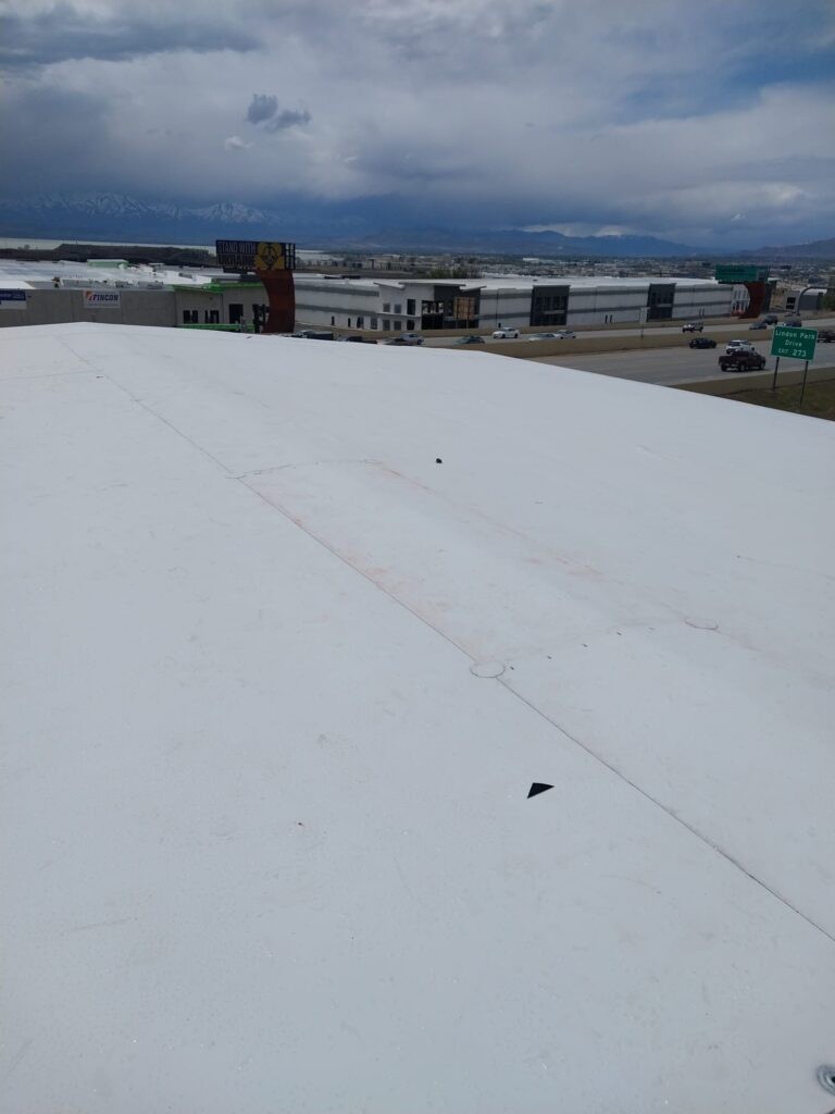 A+ Roofing Services roof installation view on commercial building under cloudy sky