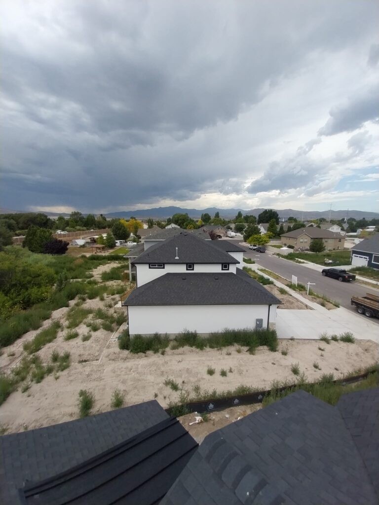 A+ Roofing Services aerial view of residential rooftops under cloudy skies