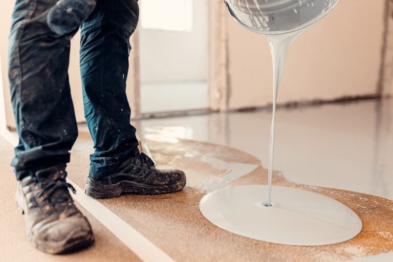 Machado Brothers LLC contractor pouring concrete leveling mix with a finishing trowel and bucket